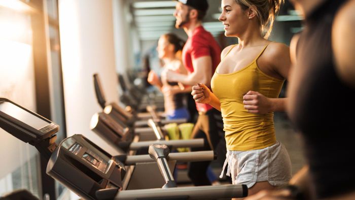 Reinigung von Fitnessgeräten in einem Fitnessstudio in München